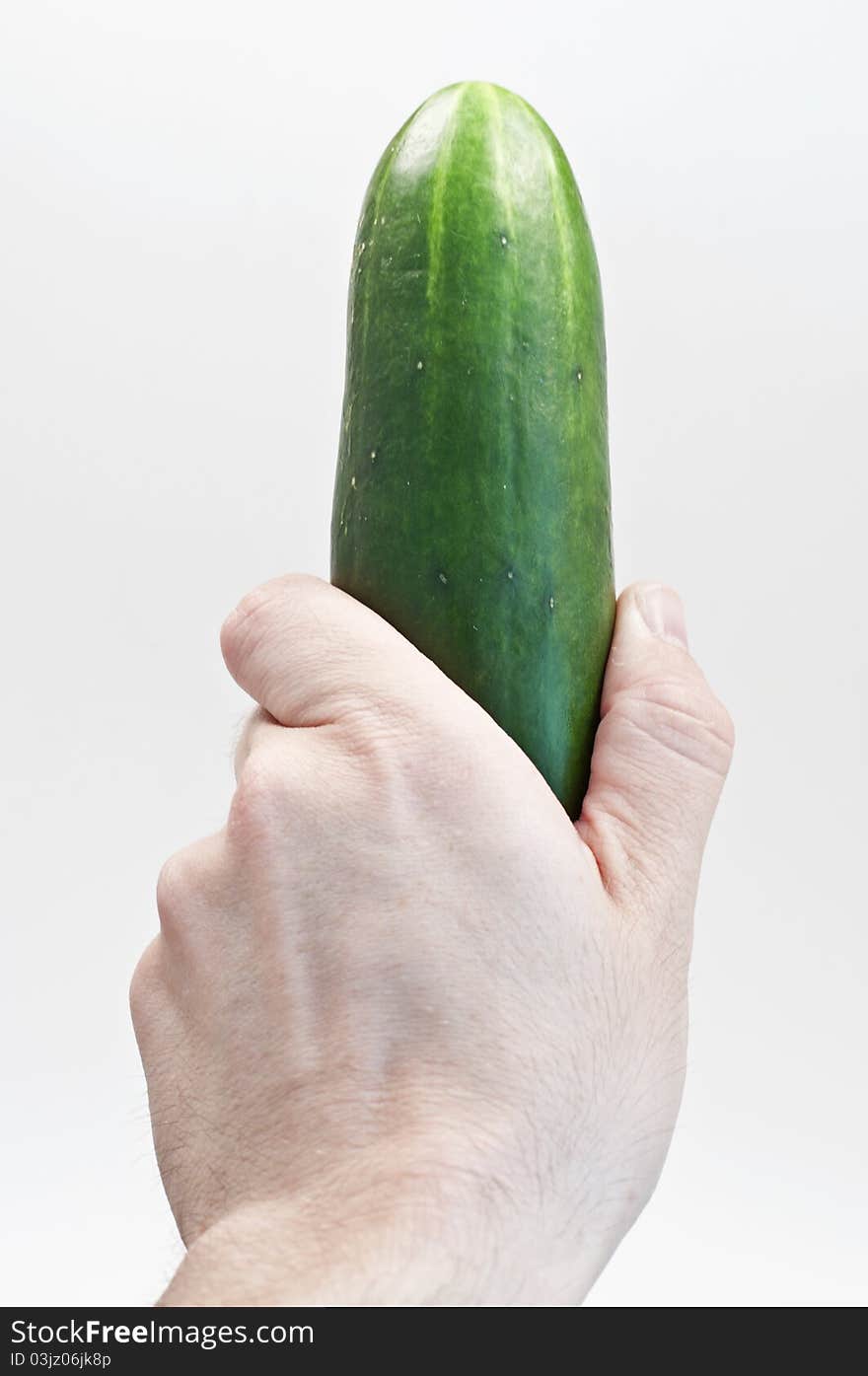 Cucumber held vertically on isolated white background