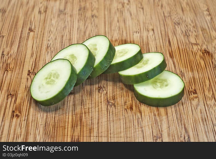 Sliced cucumber in half circle on cutting board close up