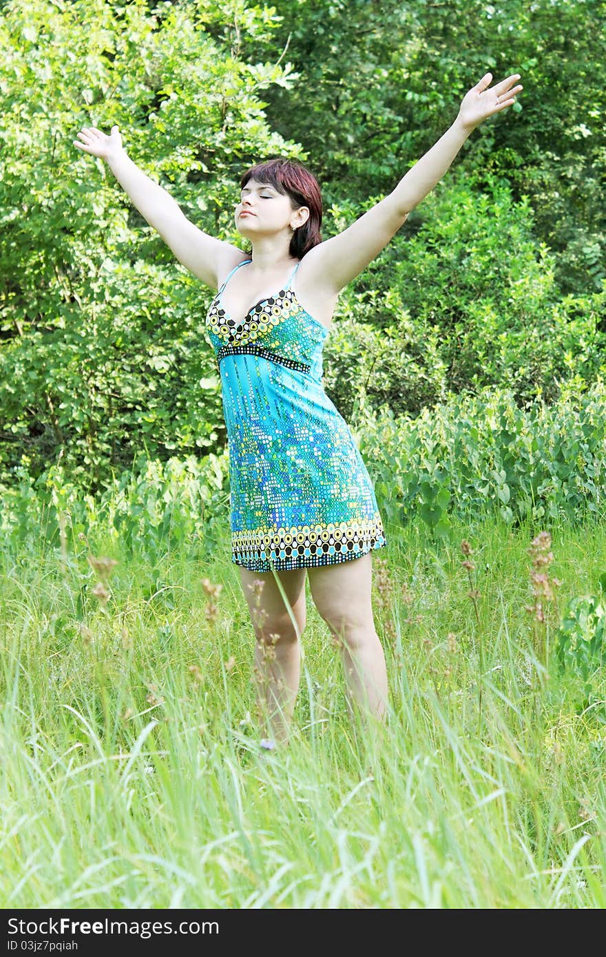 Young woman raised hands upward on nature