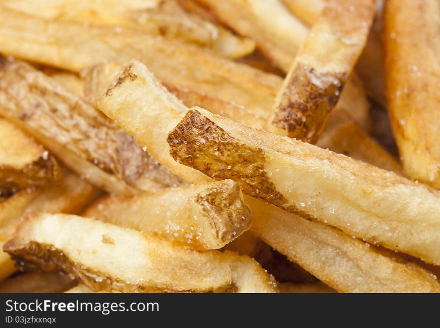 A group of hot french fries against a white background