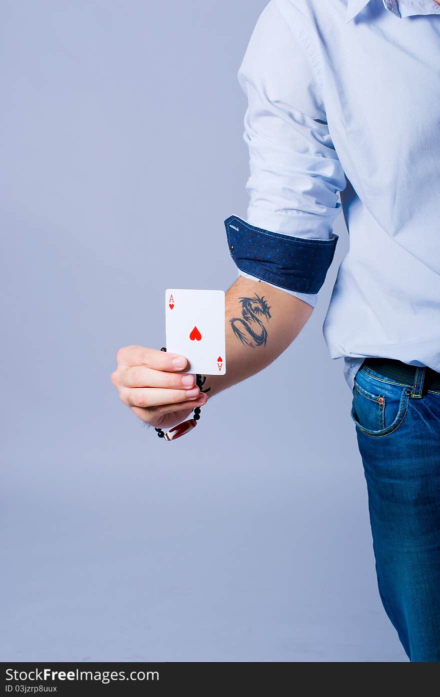 Poker player with an Ace of heart in his hand and a black dragon tatoo