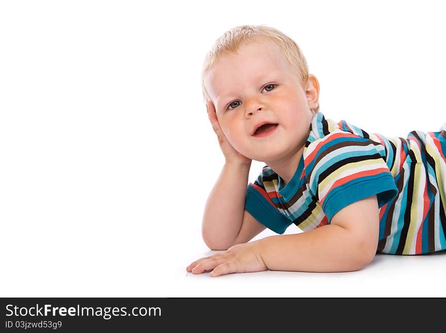 Portrait of a happy 2 year boy lying on a floor.