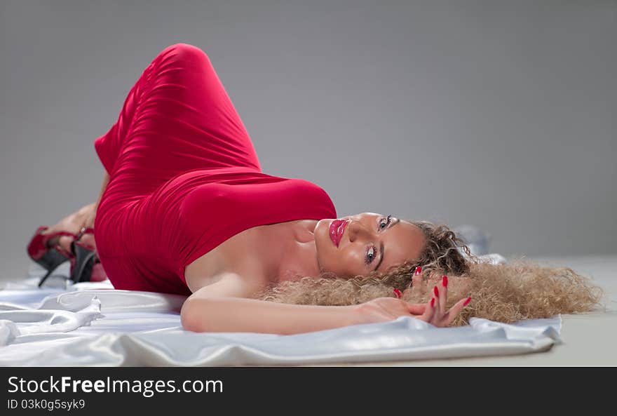 A young woman in a red dress lying on the floor