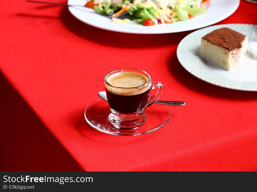 Coffee in a litte glass on red table