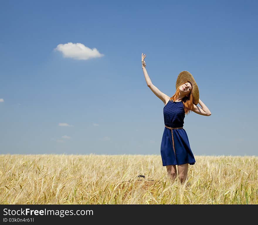 Redhead girl at spring wheat field.