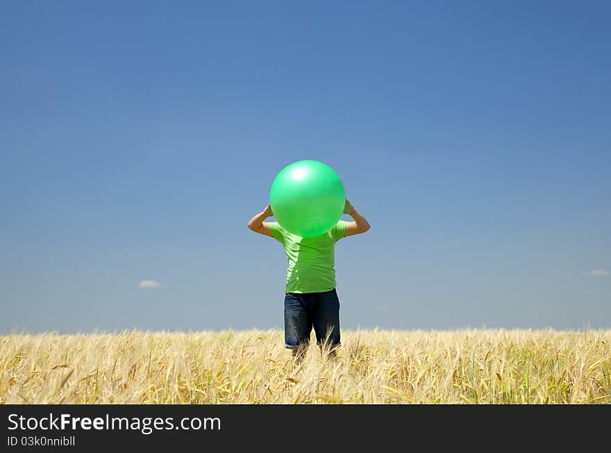 Men with green ball at wheat field.