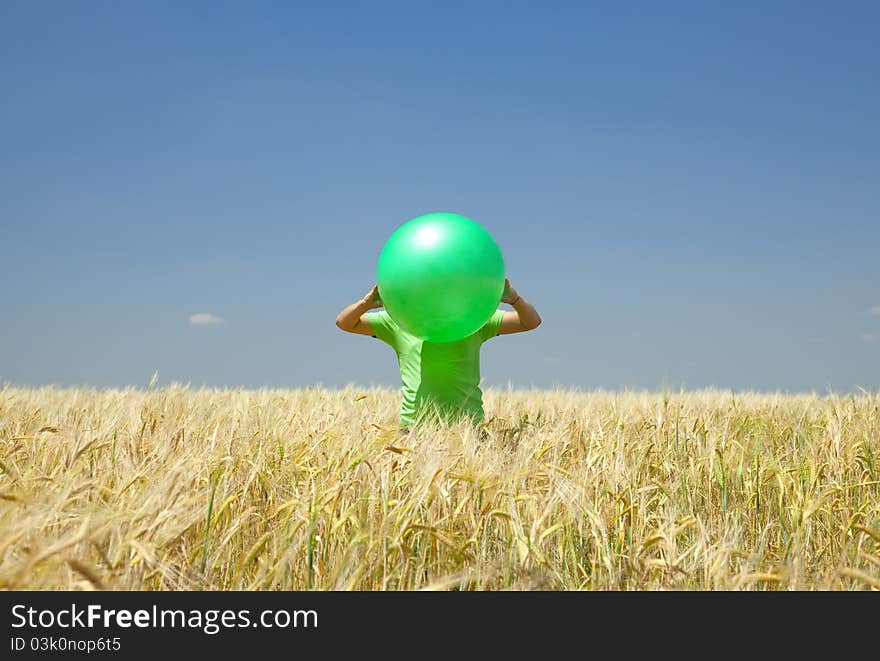 Men with green ball at wheat field.