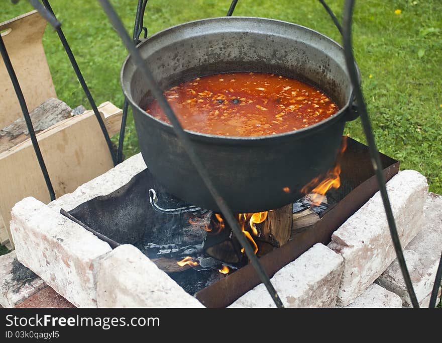 Cooking of soup in the pot on fire. Cooking of soup in the pot on fire