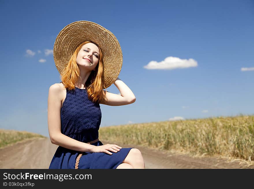 Lonely girl with suitcase at country road.