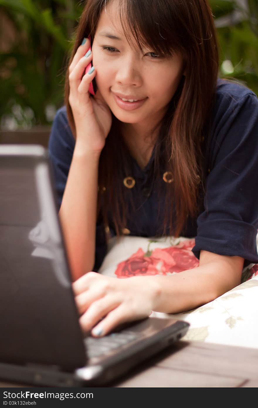 Portrait of young woman working on mobile and notebook