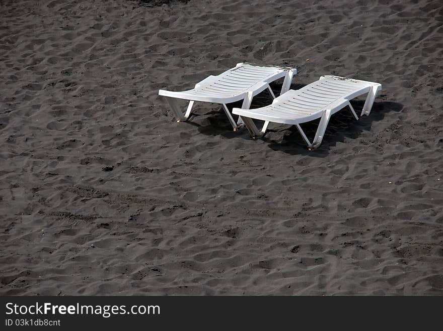 Lounge Plastic White Beds On Black Sand Beach