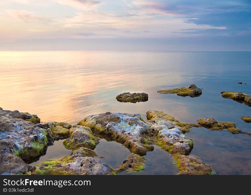 Sea and rock at the sunset. Seascape composition.