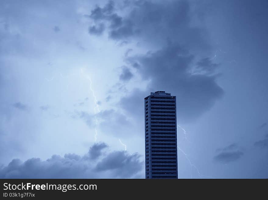 Skyscraper at night under stormy sky