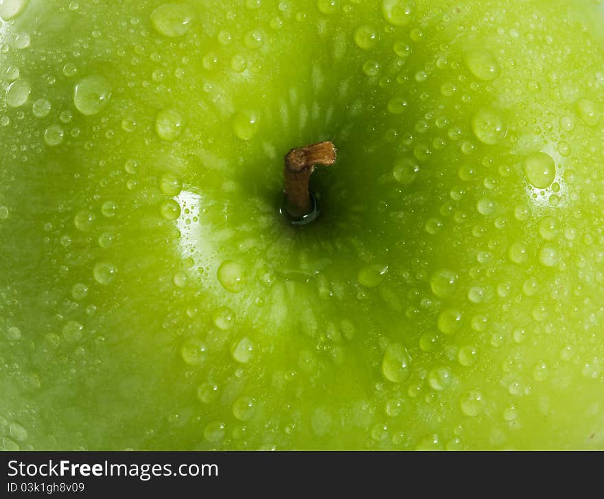 Green apple with water drops  as background