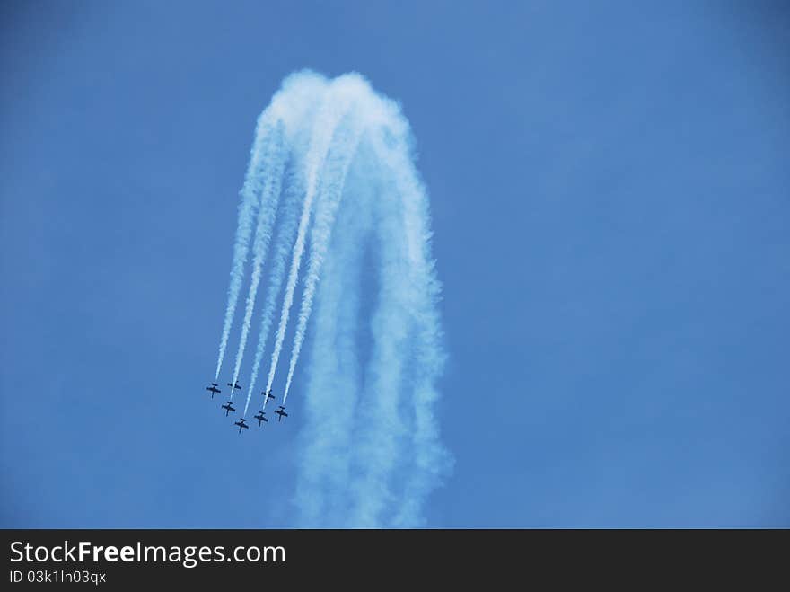 At a flight show a formation of aircraft make a looping. At a flight show a formation of aircraft make a looping