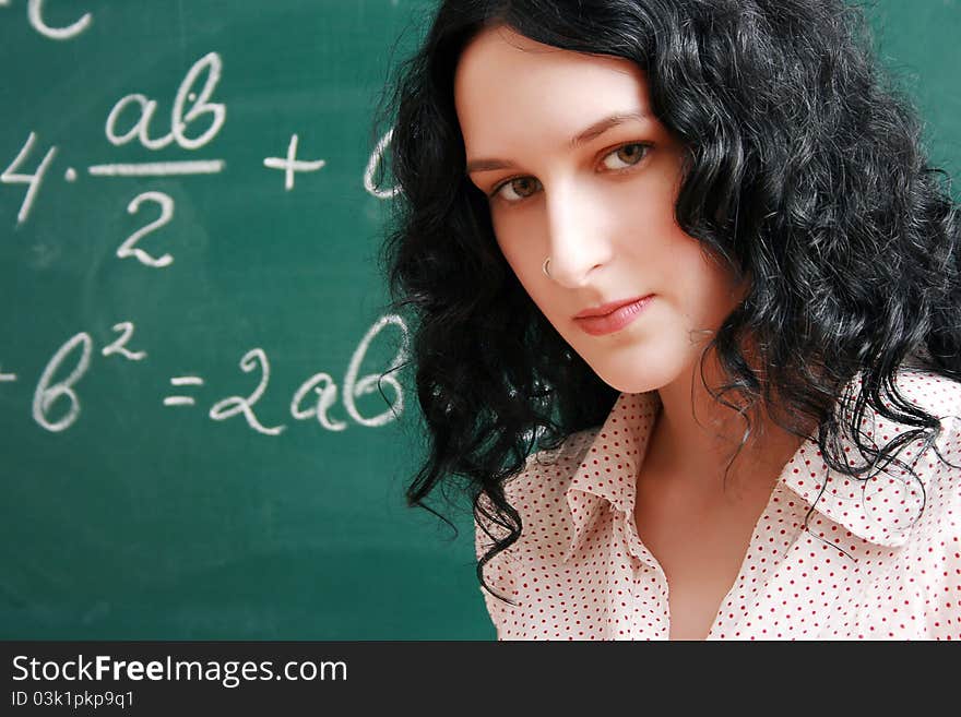 Girl at the lesson near blackboard. Girl at the lesson near blackboard