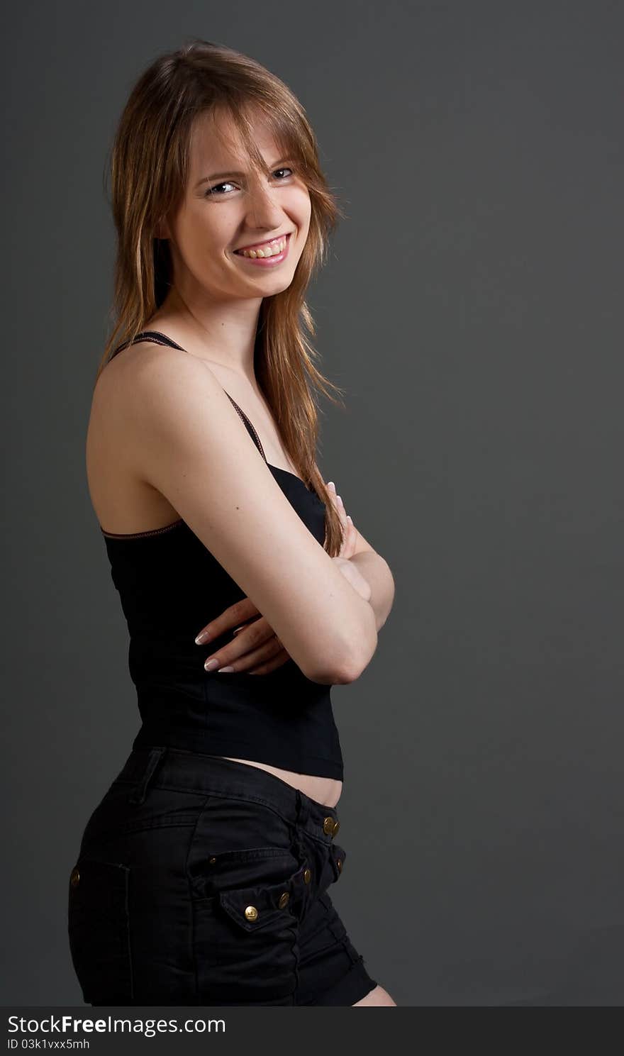 Happy fitness woman standing smiling against gray background