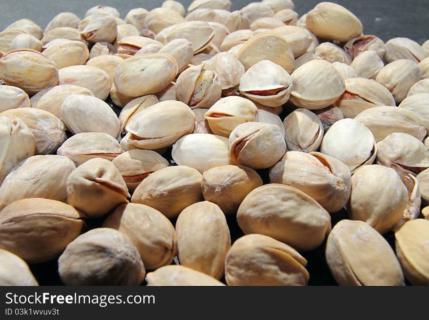 Pistachio nuts, a handful of nuts on a dark background