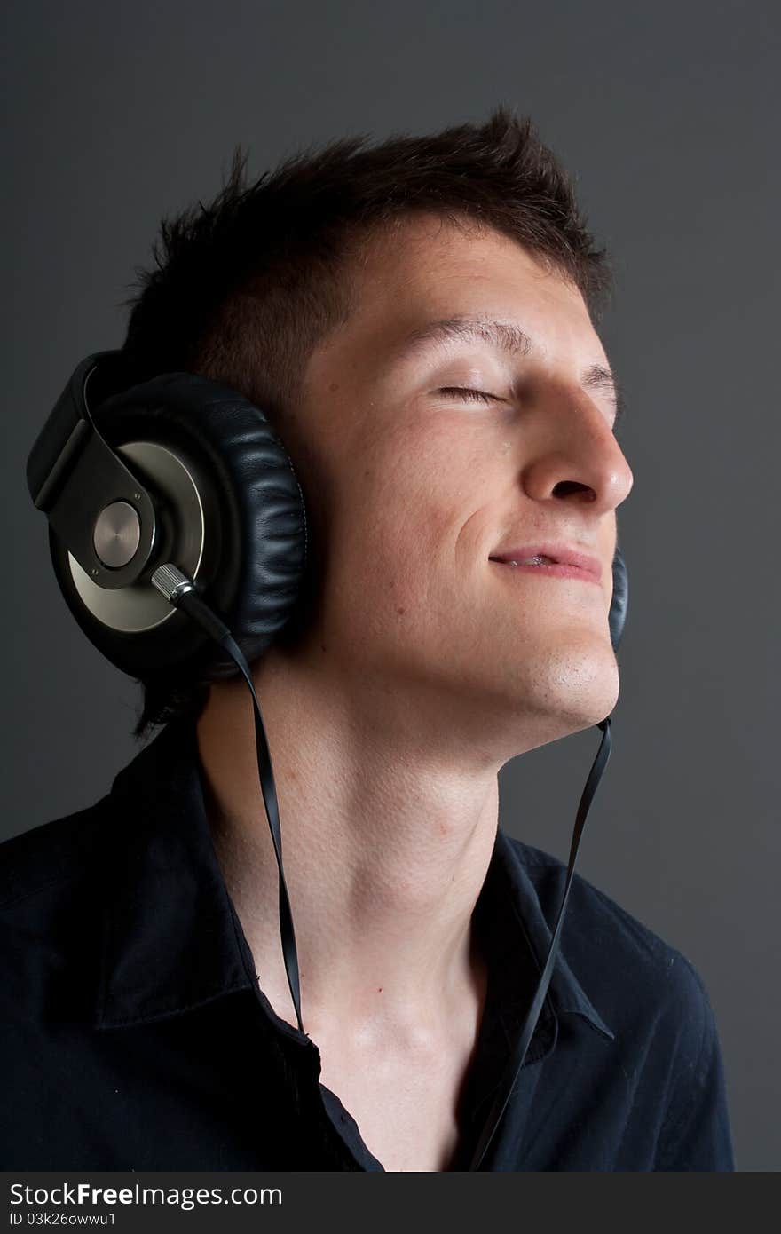 Young male person listening to music with headphones