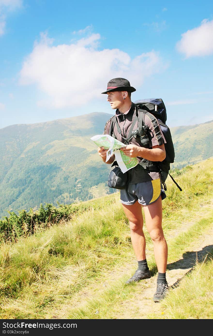 Man with the knapsack holds the map. Man with the knapsack holds the map