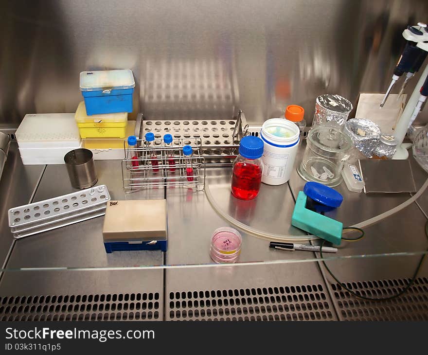 Chemicals, test tubes and pipettes in a laminar flow cabinet. Chemicals, test tubes and pipettes in a laminar flow cabinet.