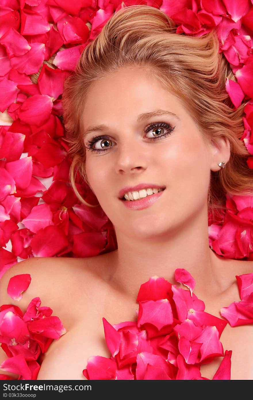 Attractive blond girl portrait in roses petals. Attractive blond girl portrait in roses petals.