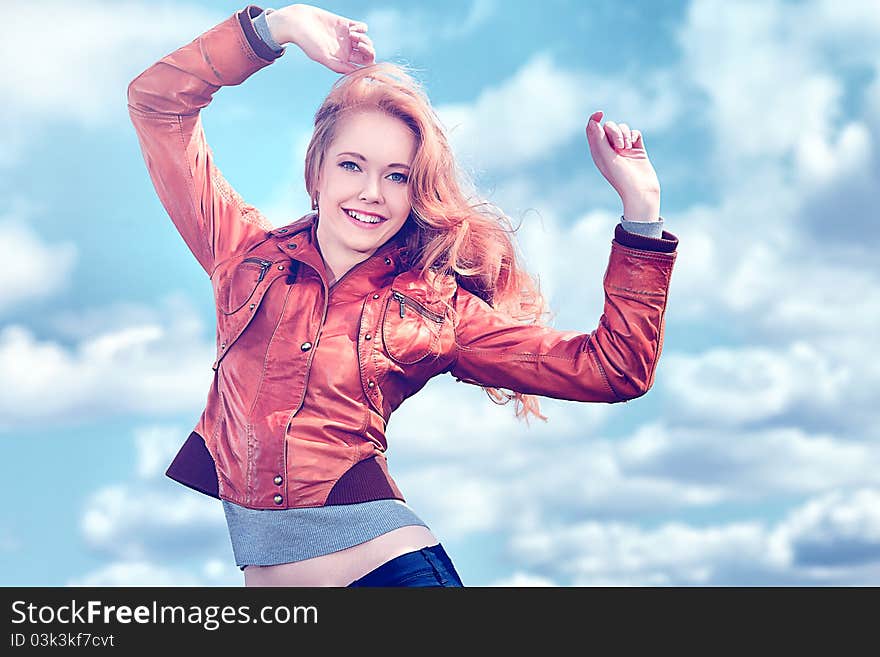 Beautiful young woman outdoors over blue sky.