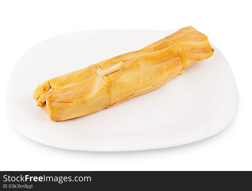 Stick of smoked cheese (pigtail) on a plate