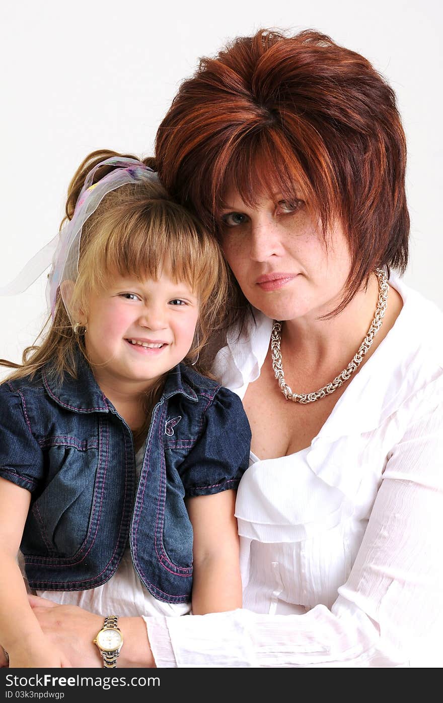 Young daughter and mother dressed in blue and white smiling. Young daughter and mother dressed in blue and white smiling