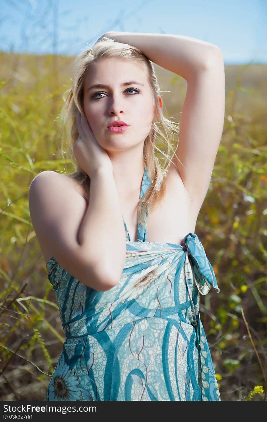 Blonde model in field with blue dress