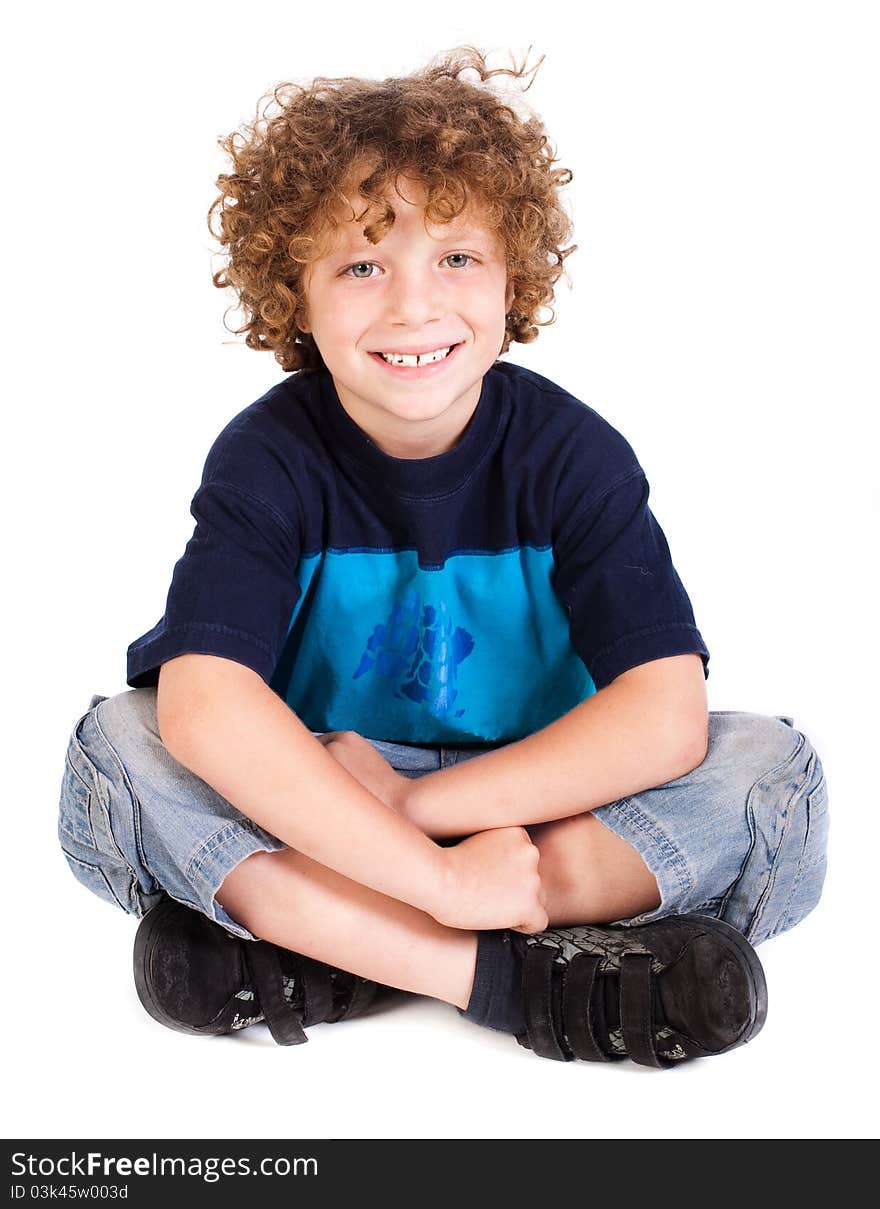 Cheerful kid relaxing on floor isoalted agianst on white.