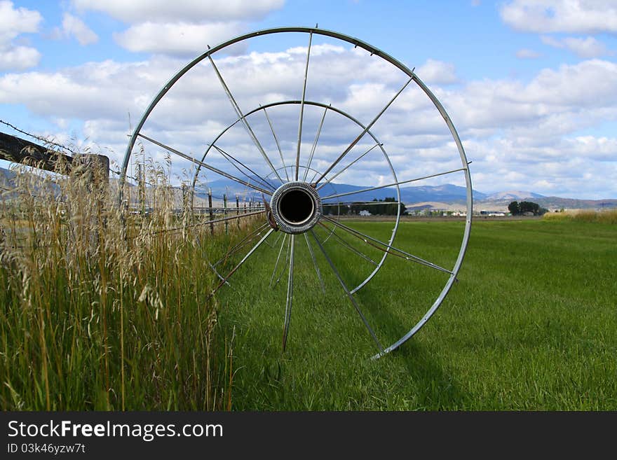 Wheeled irrigation pipe in a green field