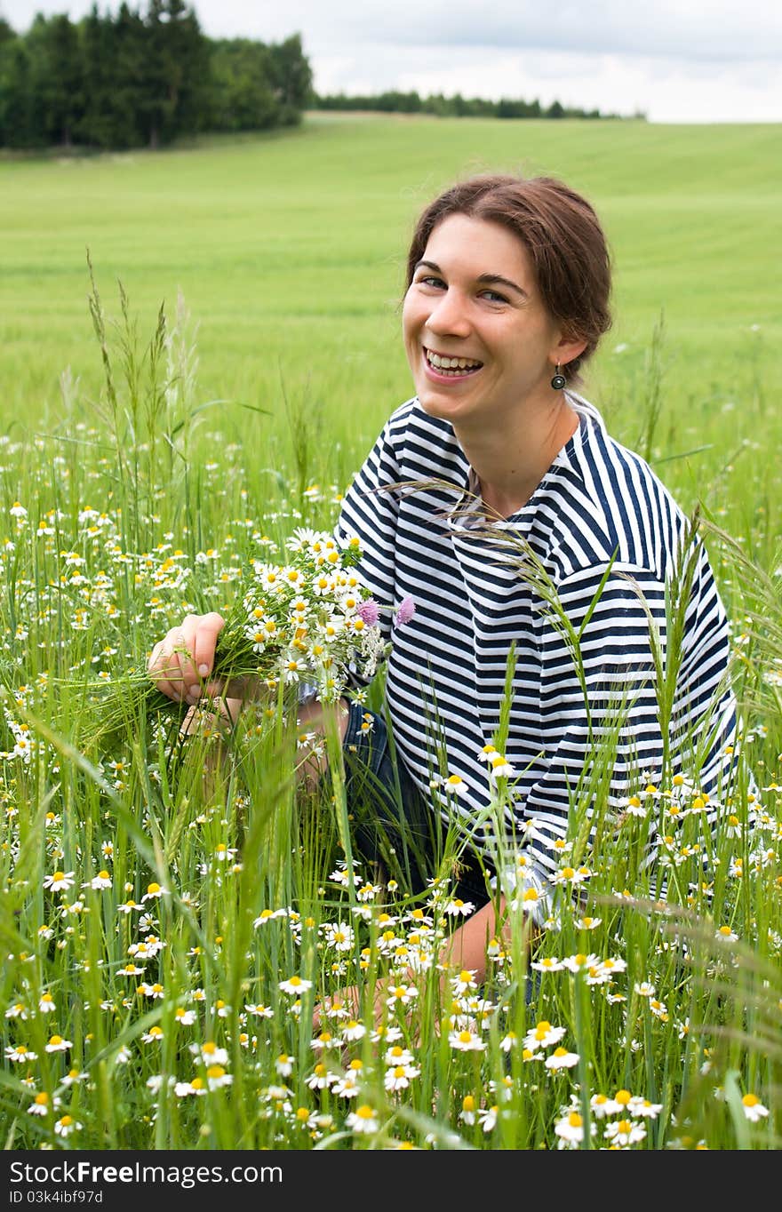 Young woman picking flowers in a field in Moravia, Czech Republic. Young woman picking flowers in a field in Moravia, Czech Republic