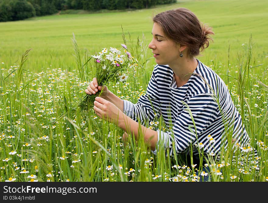 Young woman picking flowers in a field in Moravia, Czech Republic. Young woman picking flowers in a field in Moravia, Czech Republic