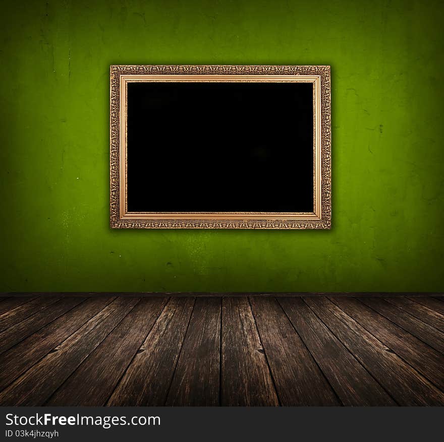 Dark vintage green room with wooden floor and golden frame hanging on the wall. Dark vintage green room with wooden floor and golden frame hanging on the wall