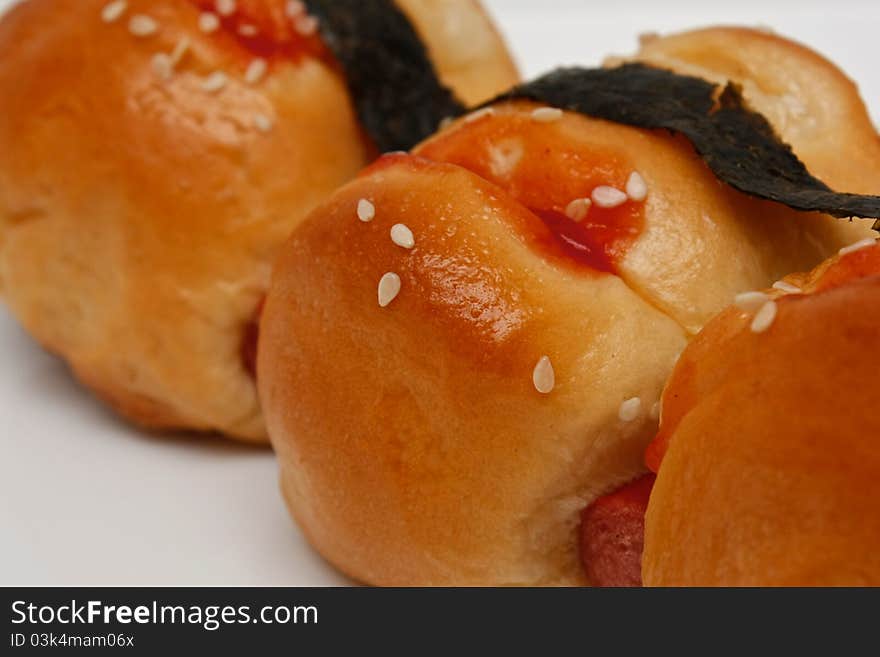 A small sausage bread with sauce and seaweed