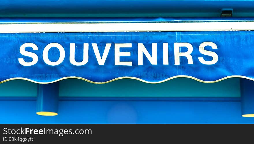 Souvenirs sign on wet blue surface