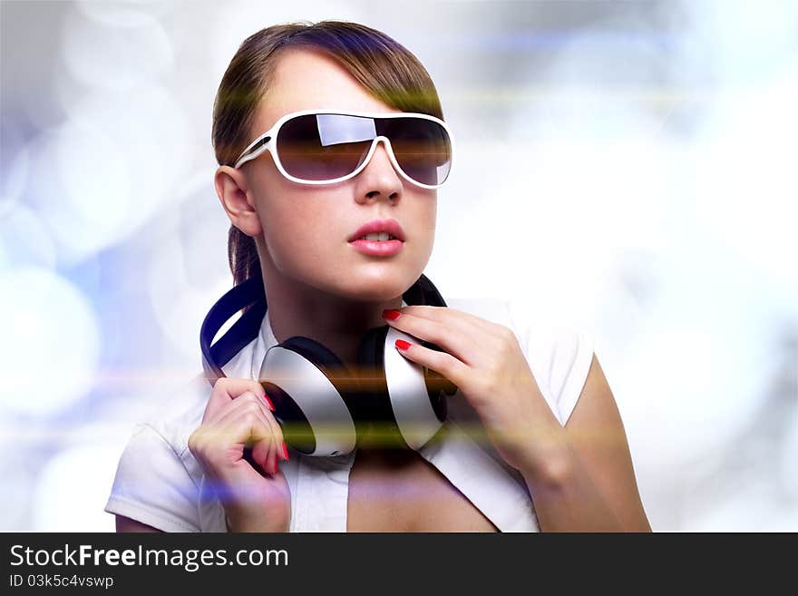 Girl with headphones on bright background