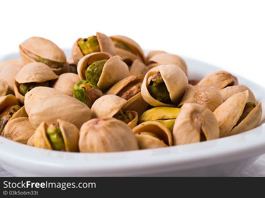 Pistachios in a bowl on the table isolated on white background