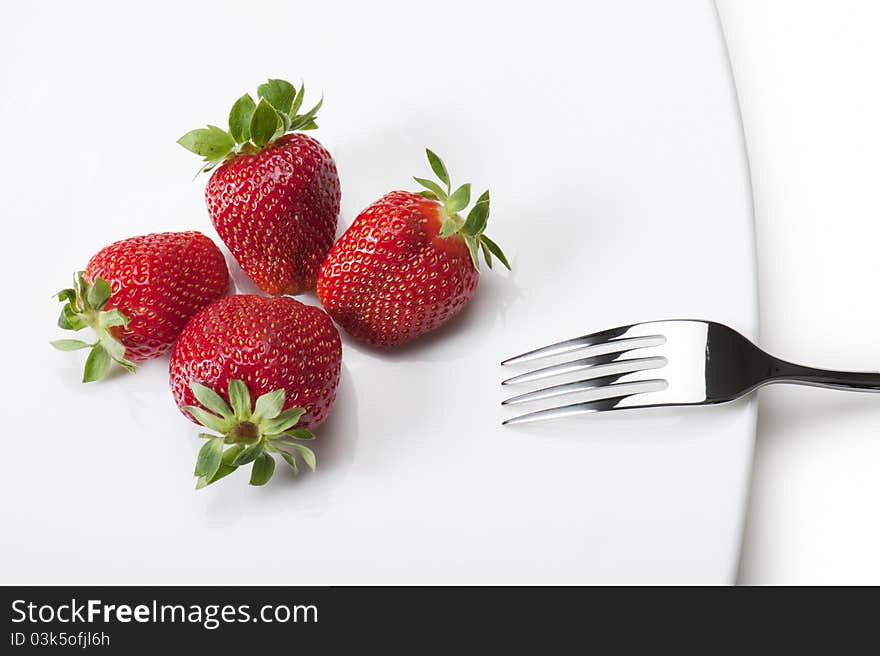 Ripe strawberries on plate with fork, on white background. Ripe strawberries on plate with fork, on white background