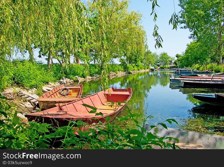 Anchored boats floating on water in small bay