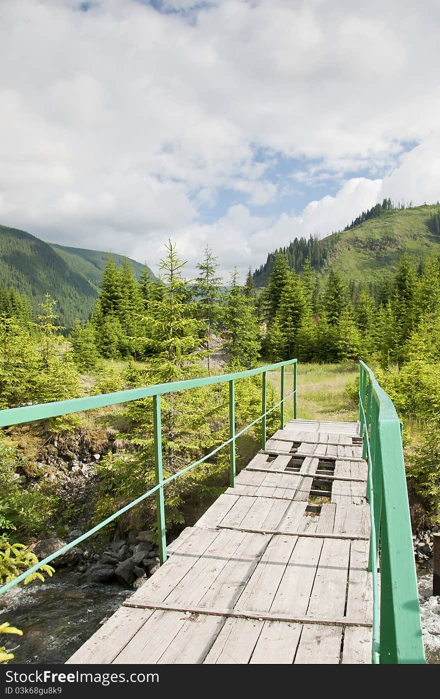 Old wooden bridge over a stream in the mountains. Old wooden bridge over a stream in the mountains