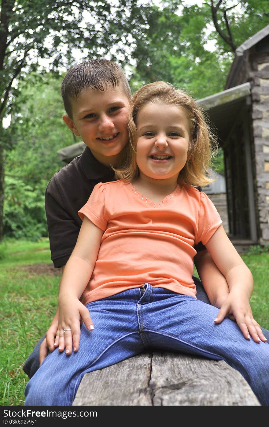 A color photograph of a brother and sister laughing. A color photograph of a brother and sister laughing