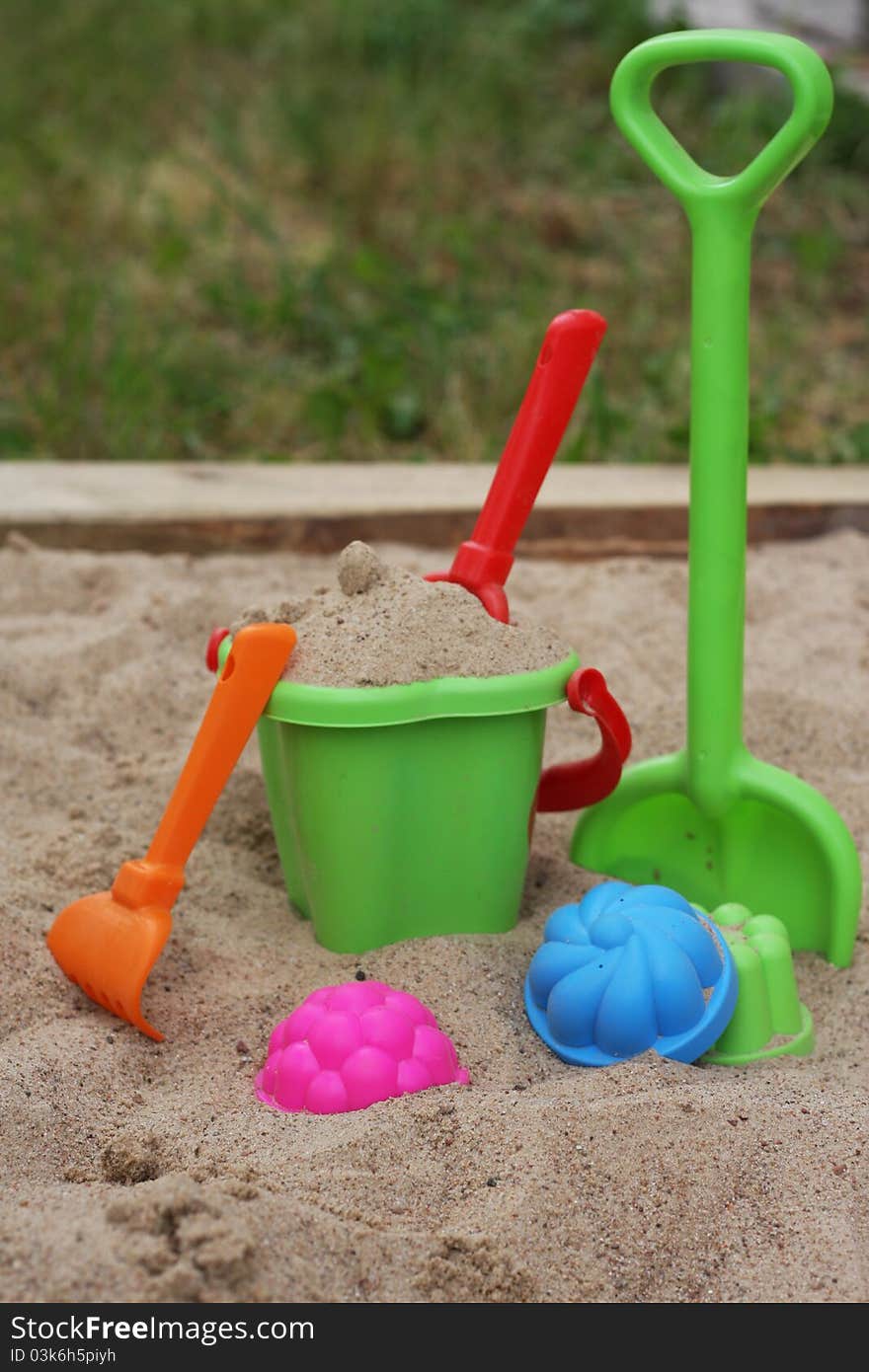 Sandbox with a multi-colored set of children's toys. Sandbox with a multi-colored set of children's toys