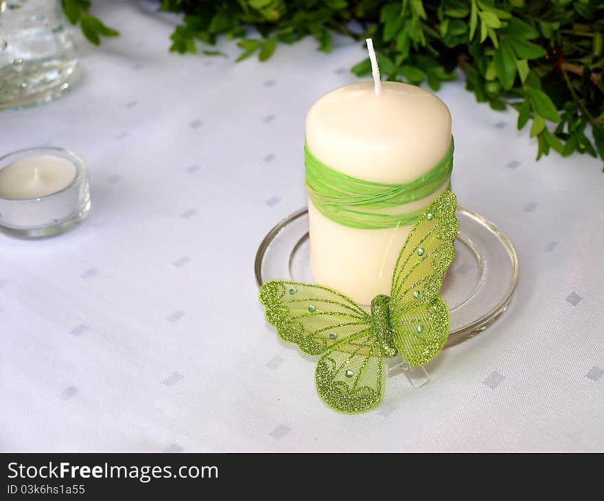 A candle and a butterfly on white background. A candle and a butterfly on white background.