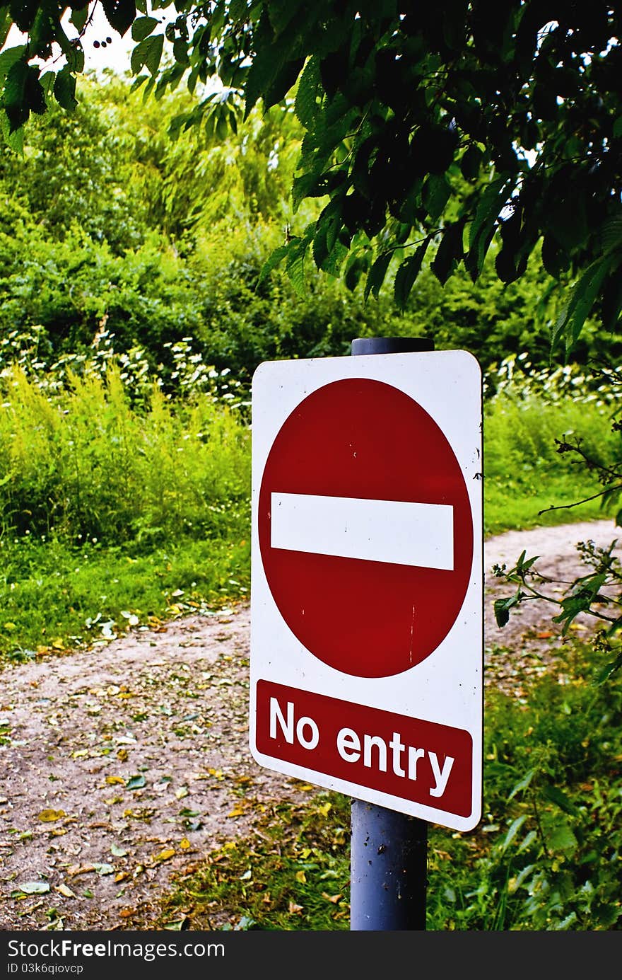 A no entry sign at the start of a dirt track