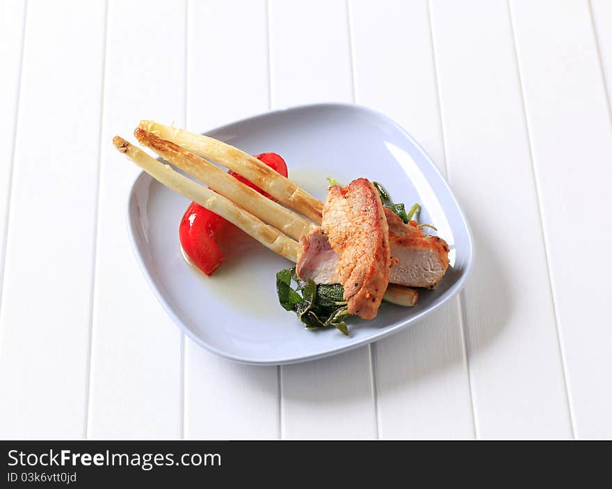 Pieces of marinated chicken and pan-fried asparagus