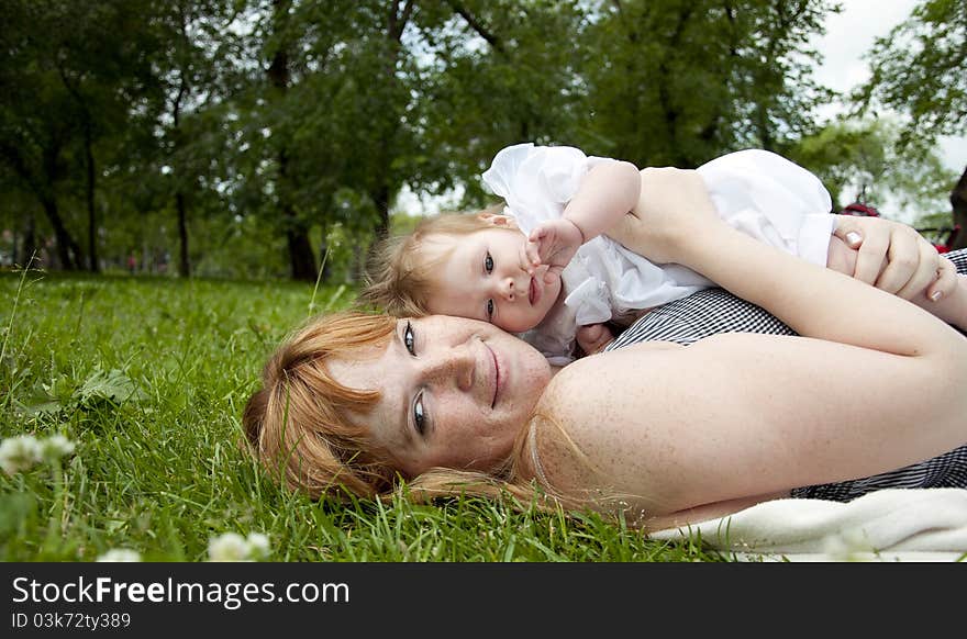 The portrait of the baby and mother on cover in the park. The portrait of the baby and mother on cover in the park