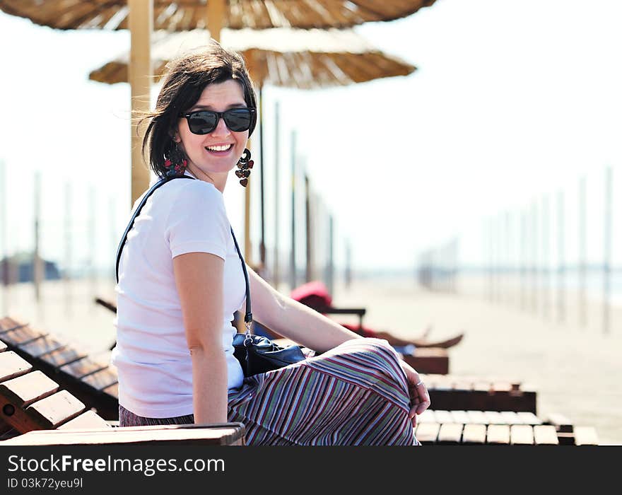 Happy young woman relax on beautiful beach at fresh summer morning and enjoy first ray of sun. Happy young woman relax on beautiful beach at fresh summer morning and enjoy first ray of sun