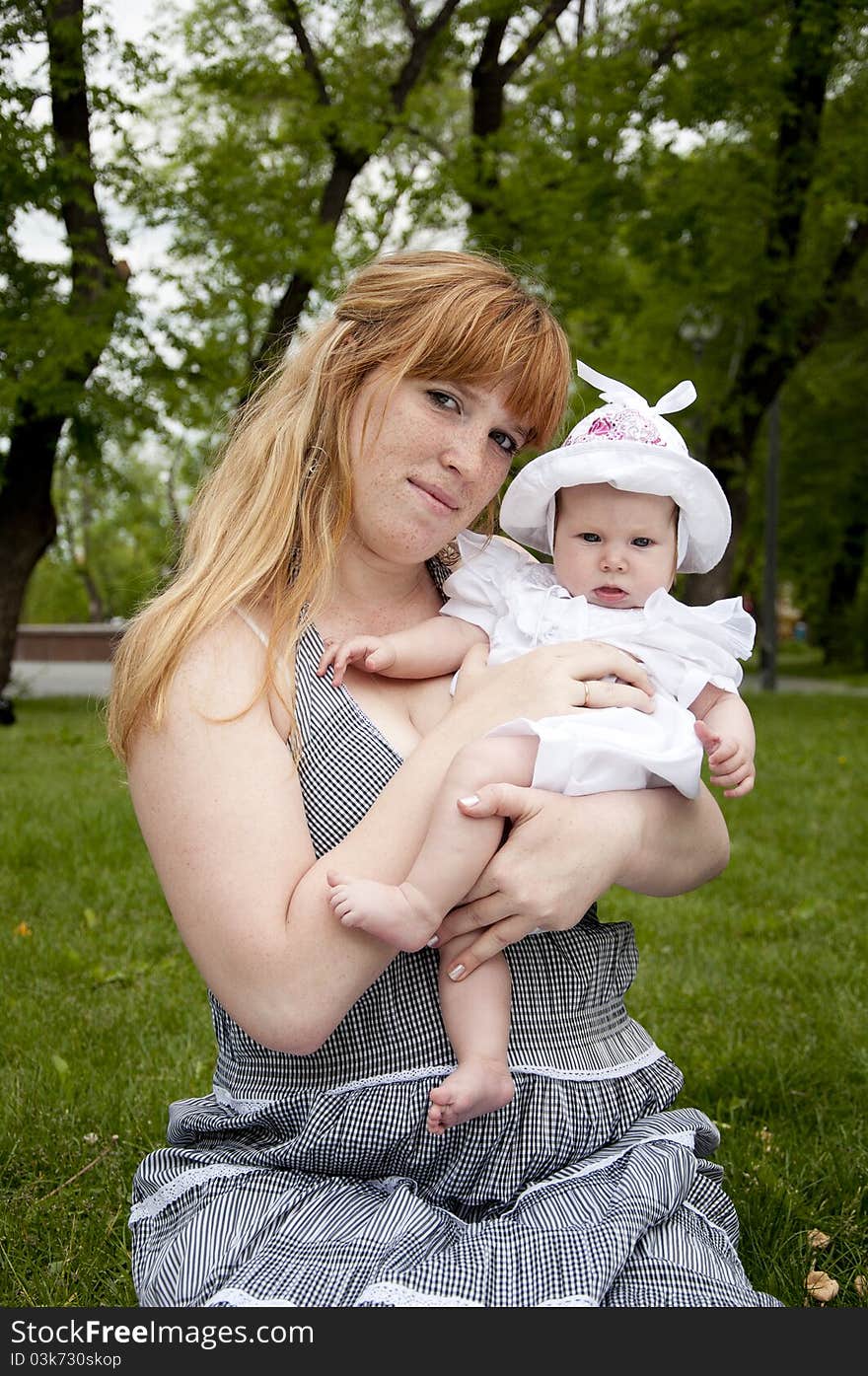 The portrait of the baby and mother on cover in the park. The portrait of the baby and mother on cover in the park